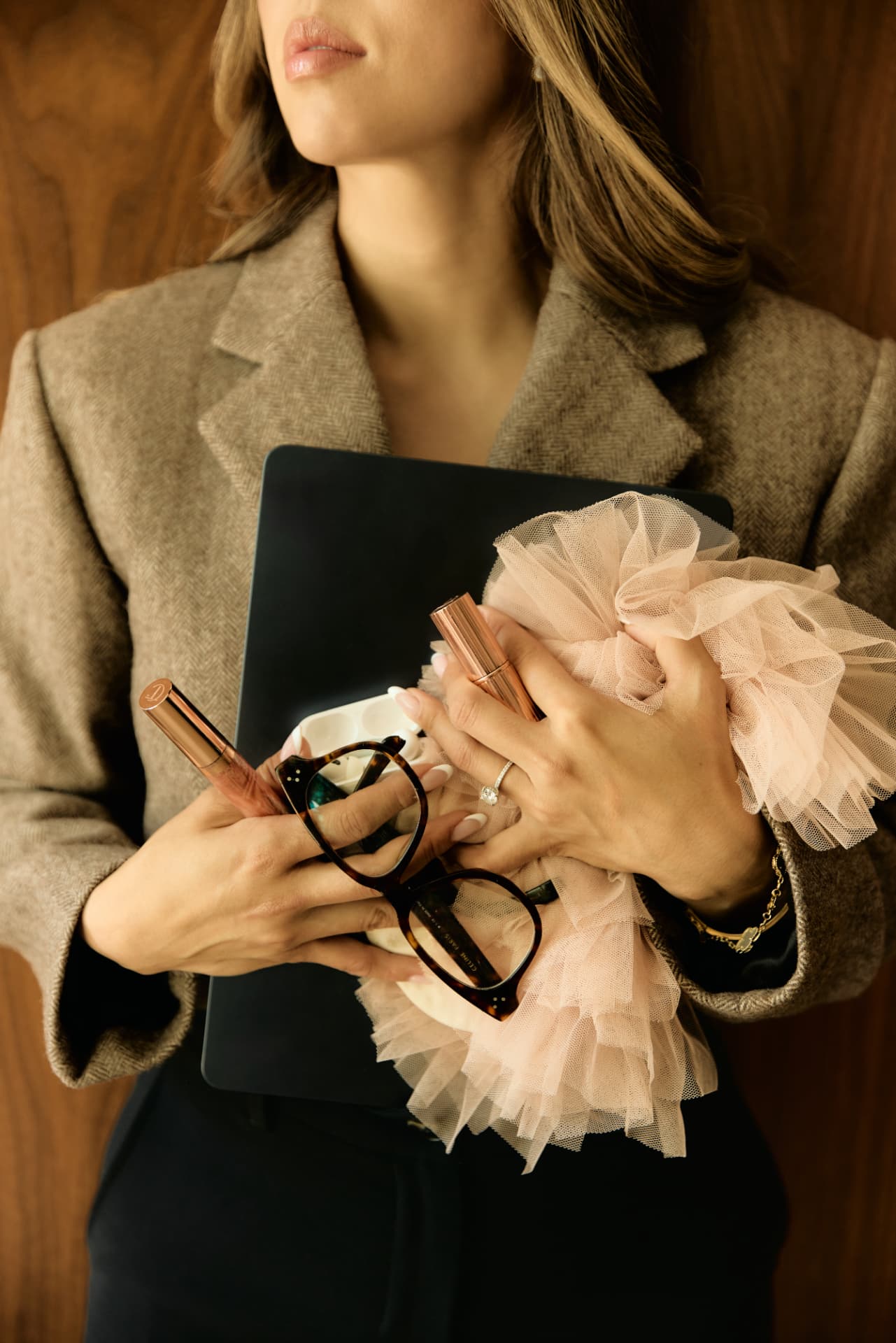 Lisa Nguyen holding a laptop, glasses and tulle wrap